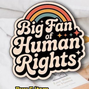 Puede incluir: Una pegatina con un diseño retro que presenta un arcoíris y las palabras "Big Fan of Human Rights" en una fuente audaz y estilizada. La pegatina tiene un fondo negro y un borde color crema. La pegatina está sobre una superficie blanca.