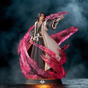 May include: A detailed figurine of a character from the anime series Bleach. The figure is dressed in a black and white outfit with a long coat, and is surrounded by pink energy effects. The base is black with a gold trim.