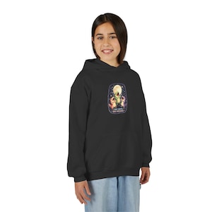 Könnte beinhalten: Schwarzer Kapuzenpullover mit einem farbenfrohen Aufdruck von drei Zeichentrickfiguren unter einem Vollmond und dem Text "Tiny Arms, Big Dreams". Der Pullover hat eine Kängurutasche und eine Kapuze mit Kordelzug.