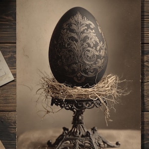 May include: A sepia-toned image features a large, dark egg with intricate gold floral patterns, resting in a nest atop an ornate, dark metal stand. The egg is the focal point, with the stand and nest adding to the vintage aesthetic. The background is a neutral tone.