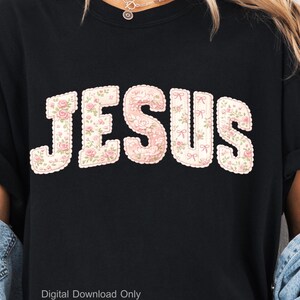Może przedstawiać: Czarna bluza z napisem "JESUS" dużymi literami we wzór kwiatowy. Litery są obrysowane na biało z różowymi kokardkami. Wzór kwiatowy przedstawia różowe róże i zielone liście. Tekst "Digital Download Only" znajduje się na dole.