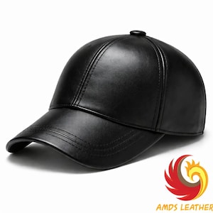 May include: A black leather baseball cap with a curved brim. The cap has a structured crown and a small button on top. The brand name "AMDS LEATHER" is visible in the bottom right corner.
