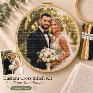 May include: A custom cross stitch kit featuring a circular wooden hoop containing a stitched portrait of a couple in wedding attire, accompanied by a reference photograph, embroidery floss in green, gold, beige, and black, and fabric.