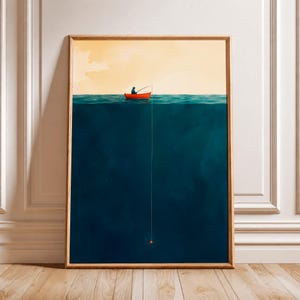 Op de afbeelding: Een ingelijste verticale kunstdruk met een kleine rode boot met een eenzame figuur die vist op een kalme zee. De compositie is verdeeld tussen een lichtgele lucht en een diepdonkerblauwe oceaan, met een dunne vislijn.