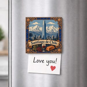 May include: A square refrigerator magnet featuring an illustration of the Santiago de Chile skyline with snow-capped mountains, a glass of red wine, and grapes. A white paper note with the text Love you! and a red heart is attached below.