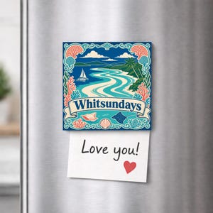 May include: A square refrigerator magnet featuring a colourful illustration of the Whitsundays with a sailboat, coral, and sea life, with the text "Whitsundays" on a banner. A white note with the handwritten text "Love you!" and a red heart is attached.