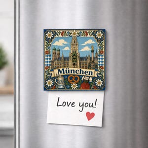 May include: A square refrigerator magnet featuring an illustration of the Munich city hall, a beer stein, a pretzel, and a traditional dress, with the text "München" on a banner. A white note with the handwritten text "Love you!" and a red heart is attached.