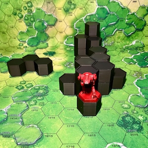 Puede incluir: Una configuración de juego de mesa con un tablero de juego hexagonal verde y blanco. Estructuras hexagonales negras están dispuestas en el tablero, con una figura de robot roja. El tablero tiene etiquetas de texto, incluyendo "LEVEL 1414" y "1614".