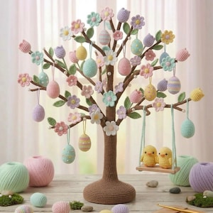 Może przedstawiać: Ręcznie robione szydełkowe drzewko wielkanocne z pastelowymi jajkami i kwiatami. Drzewko ma brązowy pień i gałęzie ozdobione wiszącymi jajkami w odcieniach różu, błękitu, żółci i fioletu. Dwa żółte pisklęta siedzą na drewnianej huśtawce.