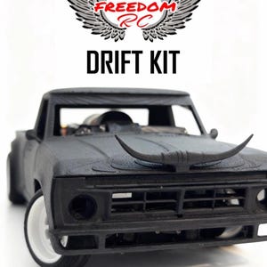 May include: Black RC drift kit truck with white wheels and a bull horn hood ornament. The text "FREEDOM RC" and "DRIFT KIT" are displayed above the truck. The truck is set against a white background.