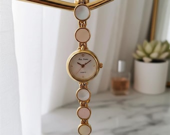 Conjunto de reloj dorado con pulsera de perlas para mujer y elegante caja de regalo color crema.