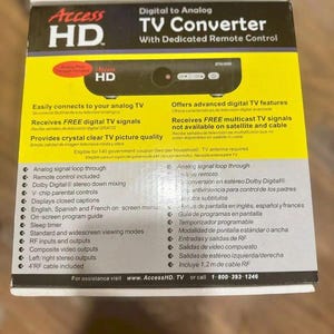 May include: A black and yellow box for an Access HD digital to analog TV converter. The packaging features a product image, a list of technical specifications including Dolby Digital stereo down mixing, V-chip controls, and a 4-foot RF cable.