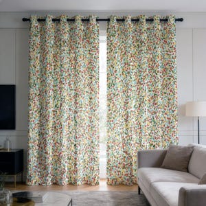 May include: Two patterned window curtains with a colorful design. The curtains feature a repeating pattern of small, irregular shapes in shades of red, green, yellow, and blue against a white background. The curtains are hung on a black rod.