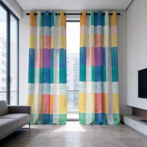 May include: Two floor-length curtains featuring a vertical and horizontal grid pattern in a vibrant multi-colored palette including yellow, blue, green, purple, and orange. The curtains are hung on a black rod with silver-toned metal grommets.