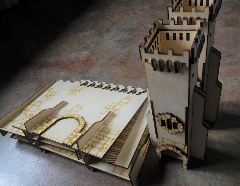 K&ouml;nnte beinhalten: Ein Holzmodell einer Burg mit einem Turm und einem Hof. Der Turm hat ein Zinnendach und ein kleines Fenster. Der Hof besteht aus einer Reihe von Quadraten.