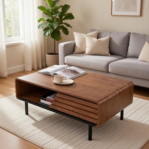 May include: A contemporary coffee table with a rich wood veneer and black metal legs. The table has a storage shelf with a slatted front. A cup and saucer are on the table, along with an open book. The table is approximately 120 cm long.