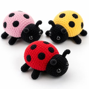 Può includere: Tre coccinelle all'uncinetto in rosa, giallo e rosso. Ogni coccinella ha macchie nere, una testa, zampe e antenne nere e grandi occhi rotondi. Le coccinelle sono fatte a mano e sembrano morbide e soffici.