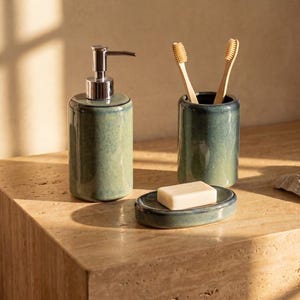 Peut inclure: Un ensemble d'accessoires de salle de bain comprenant un distributeur de savon cylindrique avec une pompe argentée, un porte-brosses à dents assorti avec deux brosses en bambou et un porte-savon ovale avec un savon blanc.