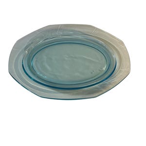 Può includere: Un piatto da portata ovale azzurro con un bordo trasparente leggermente strutturato. Il piatto ha un bordo rialzato e un interno ovale liscio. La forma generale è un ottagono arrotondato. Questo piatto vintage è perfetto per servire cibo.