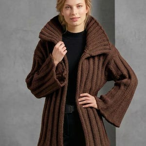 May include: A dark brown, chunky knit cardigan featuring a wide, oversized ribbed collar and long, flared sleeves. The garment is crafted with a prominent vertical ribbed texture throughout, providing a structured yet relaxed fit that hangs open at the front.
