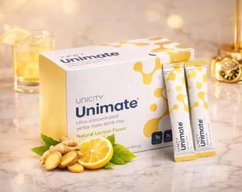 May include: A box of Unicity Unimate yerba mate drink mix with two packets, a glass of drink, a sliced lemon, ginger, and a gold watch. The box and packets have the Unimate logo and text.