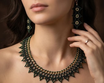 May include: A beaded jewelry set featuring a necklace and earrings. The necklace and earrings are dark green with gold accents. The necklace has a geometric design with a scalloped edge. The earrings are long and dangle, with a starburst design.