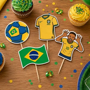 Puede incluir: Una disposición festiva con cupcakes con glaseado verde y azul, decoraciones de la bandera brasileña y un balón de fútbol, y un recorte de Neymar. Confeti amarillo y verde y un plato de campo de fútbol completan la escena.