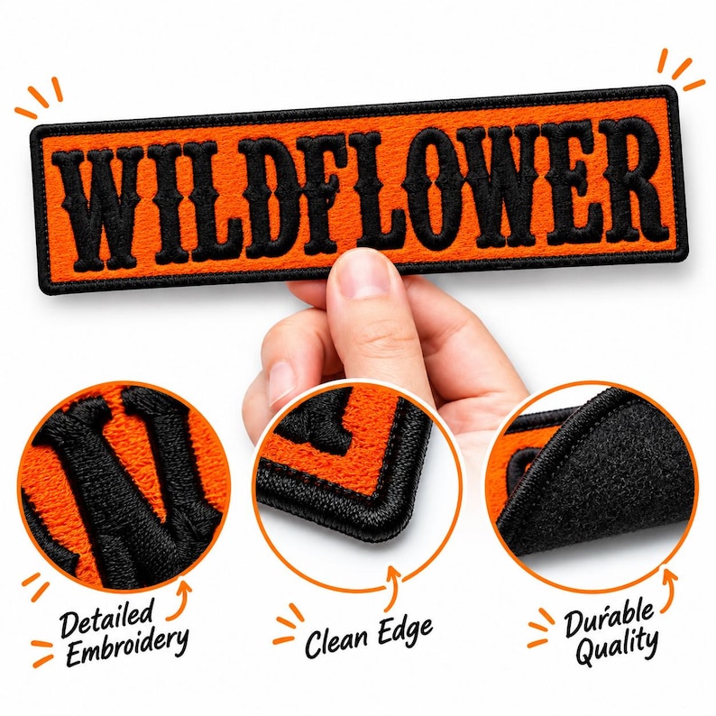 May include: A rectangular embroidered patch featuring the word WILDFLOWER in bold black lettering on a bright orange background. The patch has a black stitched border and is shown with close-up circular insets highlighting the embroidery.