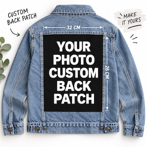 May include: A blue denim jacket featuring a large rectangular black patch on the back with the white text YOUR PHOTO CUSTOM BACK PATCH. The patch measures 32 cm in width and 26 cm in height. The jacket includes text reading CUSTOM BACK PATCH and MAKE IT YOURS.