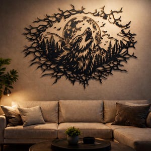 Puede incluir: Arte mural de metal negro que representa un lobo aullando frente a una luna llena, rodeado de un bosque y ramas. La obra de arte está montada en una pared de tonos neutros sobre un sofá beige, creando un tema inspirado en la naturaleza.
