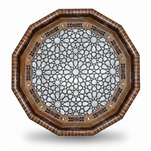 May include: An octagonal wooden tray featuring an intricate geometric star pattern inlaid with iridescent mother-of-pearl. The border displays a multi-coloured striped wood veneer with dark brown, tan, and white accents surrounding the centre.