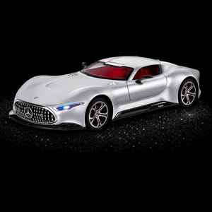 Peut inclure: Une voiture miniature Mercedes-Benz GT argentée dotée d'une carrosserie aérodynamique élégante, d'une calandre proéminente avec l'emblème Mercedes, de sièges intérieurs rouges et de roues à rayons multiples. Le véhicule présente un design bas.