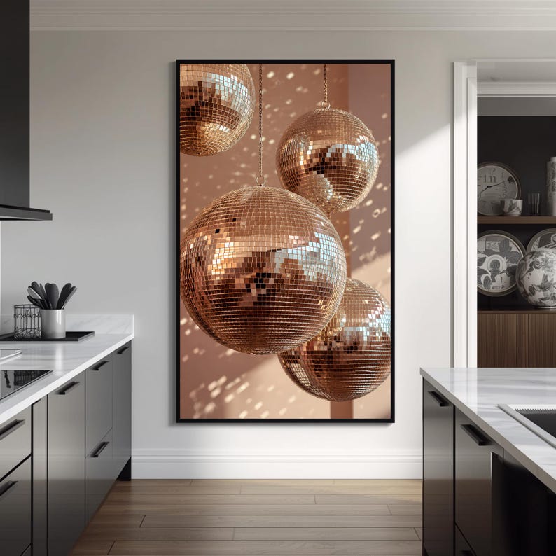 K&ouml;nnte beinhalten: Ein vertikales gerahmtes Wandbild, das vier ros&eacute;goldene Discokugeln zeigt, die in unterschiedlichen H&ouml;hen vor einem sanften pfirsichfarbenen Hintergrund h&auml;ngen und ein reflektierendes Mosaikmuster aus Licht und Schatten auf jeder Kugel erzeugen.