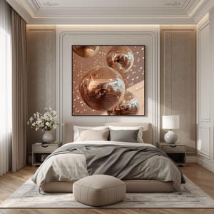 K&ouml;nnte beinhalten: Ein quadratischer Wandkunstdruck mit drei reflektierenden ros&eacute;goldenen Discokugeln, die vor einem sanften pfirsichfarbenen Hintergrund h&auml;ngen, wobei verstreute Lichtreflexionen einen schimmernden Effekt auf der Oberfl&auml;che des Kunstwerks erzeugen.