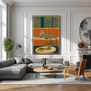 Peut inclure: Une impression d'art mural encadr&eacute;e repr&eacute;sentant un l&eacute;opard allong&eacute; sur un canap&eacute; orange avec un verre &agrave; martini, devant des stores horizontaux vert fonc&eacute;. Une table ronde au premier plan porte une petite plante et deux livres.