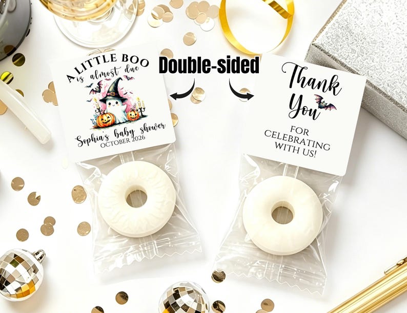 May include: Two white ring-shaped candies in clear plastic bags with square paper toppers. The left topper says A LITTLE BOO is almost due, Sophia's baby shower, OCTOBER 2026 with a ghost, pumpkins, and bats. The right topper says Thank You.