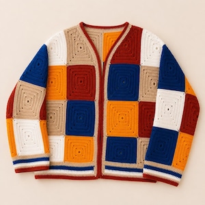 Op de afbeelding: Een vest met lange mouwen gemaakt van veelkleurige gehaakte granny squares in tinten donkerrood, feloranje, koningsblauw, beige en wit. Het kledingstuk heeft een V-hals, een open voorkant en geribbelde boorden met horizontale strepen.