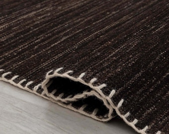 Alfombra Kilim de lana en color marrón chocolate oscuro, tejida a mano con tejido plano y disponible en tamaños personalizados.