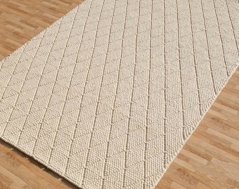 Handwoven ivory wool rug with textured loop weave, minimalist neutral area rug for modern living room decor