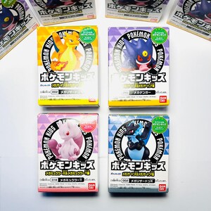 Può includere: Diverse figure da collezione Pokemon Kids in scatole. Le scatole presentano vari personaggi dei Pokemon, tra cui Charizard, Gengar, Mewtwo e Lucario. Ogni scatola ha il logo Pokemon Kids e testo giapponese.