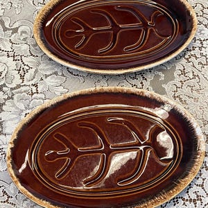 Könnte beinhalten: Ein Set aus drei Keramikbechern mit gesprenkelter, matter Oberfläche. Die Becher sind in Creme-, Hellgrau- und Dunkelgrautönen gehalten. Jeder Becher hat ein schlichtes, minimalistisches Design.