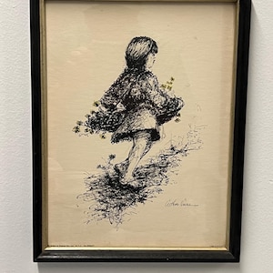May include: Framed black and white ink drawing of a child running, holding flowers. The artwork is signed by Arthur Comes. The frame is black with a gold inner border. The artwork is on a cream-colored background.