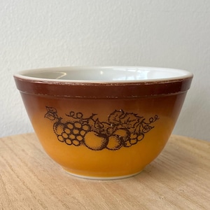 May include: A set of three ceramic mugs with a speckled, cream-colored glaze. Each mug features a different hand-painted floral design in shades of blue, green, and yellow. The mugs have a simple, modern shape.