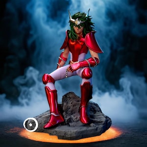 Puede incluir: Figura detallada de un personaje con armadura roja y blanca, con cabello verde y un casco plateado. La figura está sentada sobre una roca, con un fondo oscuro y ahumado. La armadura tiene detalles de cadena.