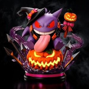 Puede incluir: Figura de Gengar morado con sombrero de bruja, bufanda naranja y negra, y una larga lengua rosa. Se encuentra sobre una calabaza naranja tallada con una cara brillante. Un bastón con una calabaza en la parte superior y remolinos de energía púrpura completan el diseño.