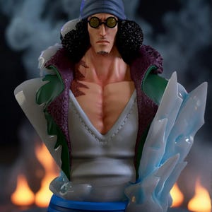 Puede incluir: Busto de un personaje con gorro azul, gafas redondas y expresión seria. La figura tiene un abrigo blanco y verde con ribetes morados y un torso musculoso. La base es azul, con estructuras de hielo a un lado.