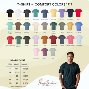 May include: A variety of Comfort Colors 1717 t-shirts in various colors, including black, white, and red. The image also displays a size chart with measurements in inches. A man is wearing a dark green t-shirt.