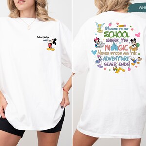 May include: White t-shirt featuring a Mickey Mouse graphic with the text "Mrs. Smith" on the front. The back of the shirt displays a colorful design with the text "Welcome to our school where the magic never stops and the adventure never ends!"