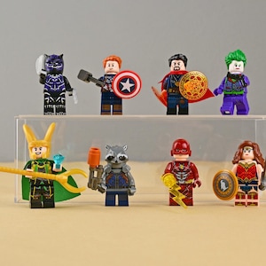 May include: A white ceramic mug with a black handle and the text "But First, Coffee" in a black, handwritten-style font. The mug is on a white surface.