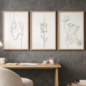 Puede incluir: Una taza de cerámica blanca con un asa negra y el texto "But First, Coffee" en negrita negra. La taza se encuentra sobre un fondo borroso, sugiriendo un ambiente acogedor.